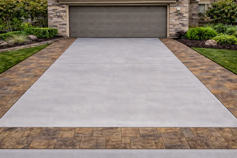 Illustration of a plain concrete driveway with paver edging leading to a residential garage